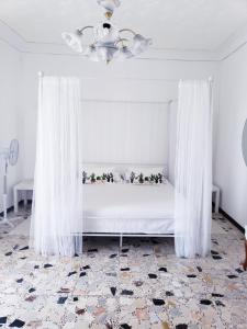 1 dormitorio con 1 cama con cortinas blancas en Mineo Townhouse with incredible views of Mt Etna en Mineo