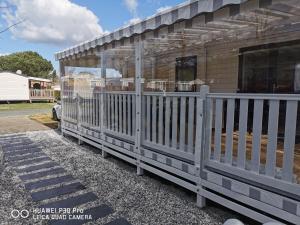 a house with a white picket fence at Camping SIBLU - La réserve in Gastes