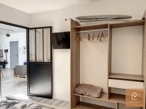 a room with a closet with a tv and a mirror at Le Loft Climatisé - 6 personnes - Entrée autonome in Châtellerault