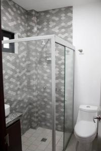 y baño con ducha de cristal y aseo. en Hermoso departamento con una excelente ubicación, en Guadalajara