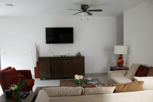 sala de estar con sofá y TV de pantalla plana en Hermoso departamento con una excelente ubicación, en Guadalajara