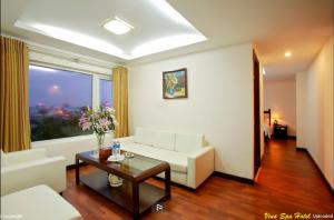 - un salon avec un canapé blanc et une table dans l'établissement Vina Spa Hotel, à Hue