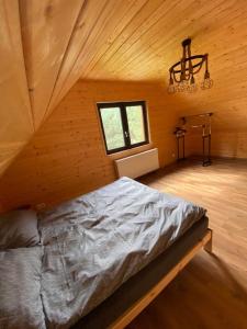 a bedroom with a bed in a wooden room at Domek Bartoszylas z sauną i balią in Bartoszylas