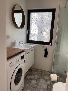 a bathroom with a washing machine and a sink at Domek Bartoszylas z sauną i balią in Bartoszylas