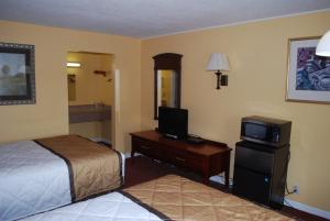 Habitación de hotel con 1 dormitorio con cama y TV en Duffys Motel - Calhoun, en Calhoun