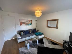 a living room with a couch and a mirror at Riverside 2 Bedroom Townhouse with Car Charger in Abergavenny