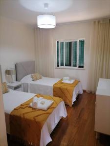 Cette chambre comprend 2 lits et une fenêtre. dans l'établissement Caniço Ocean Getaway, à Caniço