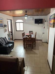 a living room with a table and a kitchen at Apartment 10 minutes by the SJO airport - in Alajuela City