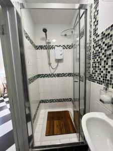 a bathroom with a shower and a sink at Causey Maisonette in Hastings