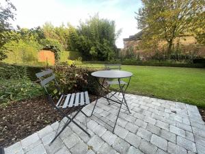 Villers-Pol的住宿－Le domaine de la Rhonelle，花园内摆放着一张桌子和两把椅子