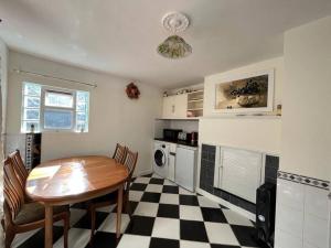 a kitchen with a table and a checkered floor at Causey Maisonette in Hastings