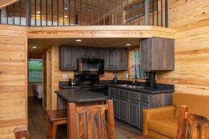 a kitchen with a stove and a sink in a cabin at Jellystone Park Tyler in Tyler