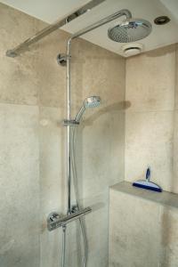 a shower with a glass door in a bathroom at Vakantieverblijf Weidezicht in Dorst +37 photos