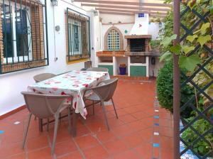 une terrasse avec une table, des chaises et une cuisinière dans l'établissement Casa de la Portuguesa, bonita terraza con barbacoa, à Güéjar-Sierra
