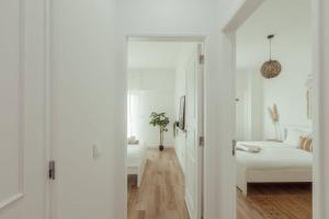 a white room with a bed and a couch at 3 bedroom apartment in Cacém in Paiõis