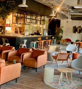 a room with couches and tables and a bar at Campanile Saint Brieuc - Centre Gare in Saint-Brieuc