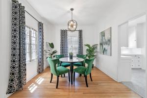 a dining room with a table and green chairs at Beverly Hills Stylish & Central 1 BR Apt + Parking in Los Angeles