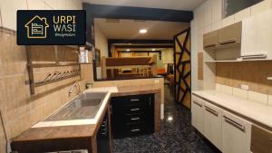 普諾的住宿－Urpi Wasi Backpackers，厨房配有水槽和台面