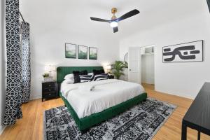 een slaapkamer met een groen bed en een plafondventilator bij Beverly Hills Stylish & Central 1 BR Apt + Parking in Los Angeles