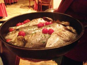 a pan of fish with cranberries on top of it at Rigat Park & Spa Hotel - Adults Recommended in Lloret de Mar