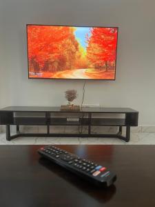 a remote control sitting on a table in front of a tv at Koselig California in Nanyuki