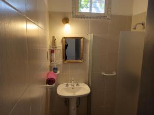 uma pequena casa de banho com um lavatório e um espelho em Belen em São Rafael