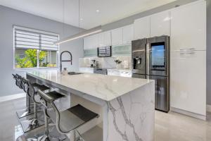 a kitchen with a large marble counter and a refrigerator at Luxury, Art, design, patio grill, near Gables,Grove,Brickell in Miami