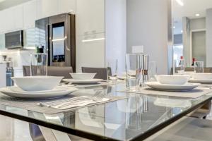 邁阿密的住宿－Luxury, Art, design, patio grill, near Gables,Grove,Brickell，玻璃桌,上面有白色的板子和餐具