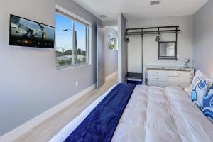 a bedroom with a large bed and a tv on the wall at Luxury, Art, design, patio grill, near Gables,Grove,Brickell in Miami