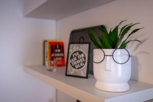 uma prateleira com um vaso de plantas e copos sobre ela em Giustiniani Apartments em Treviso