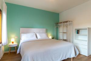 sypialnia z białym łóżkiem i niebieską ścianą w obiekcie Giustiniani Apartments w mieście Treviso