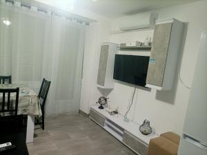 sala de estar con TV de pantalla plana en la pared en La Cubana con Aire Acondicionado, en Santa Pola