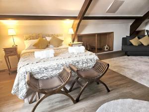 a bedroom with a large bed and two chairs at 1884 Aveiro Loft in Aveiro