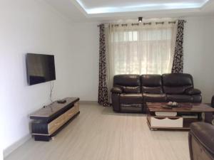 a living room with a leather couch and a table at Kagarama Residential House: in Kigali