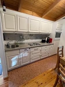 uma cozinha com armários brancos e um lavatório em Majo em Koblenz