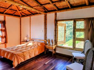 ein Schlafzimmer mit einem Bett in einem Zimmer mit Fenstern in der Unterkunft LA MARQUESA PACORA in Pácora