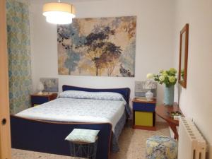 sypialnia z łóżkiem i obrazem na ścianie w obiekcie appartamento al primo piano in centro storico con terrazzo panoramico w mieście Caltagirone