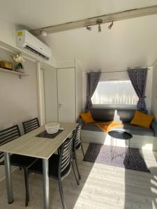 comedor con mesa, sillas y sofá en Mobil-home 5 personnes dans camping Mar Estang 4 étoiles avec accès à la plage en Canet-en-Roussillon
