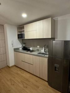 a kitchen with a stainless steel refrigerator and wooden floors at living ventto calle 18 in Bogotá
