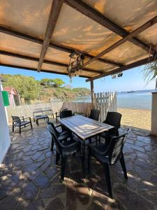a table and chairs on a patio next to the beach at casina mare sulla spiaggia in Capoliveri
