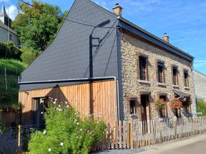 una antigua casa de piedra con techo negro en La Maison d'Anne-Marie, en Beauraing