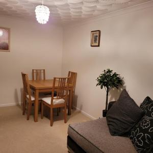 a dining room with a table and chairs and a couch at EEJs Cozy 2-Bedroom Apartment in Nailsea in Nailsea