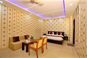 a bedroom with a bed and a couch and a table at Hotel Nexus in Lucknow