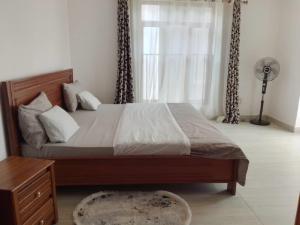 a bedroom with a large bed with a window at Kagarama Residential House: in Kigali