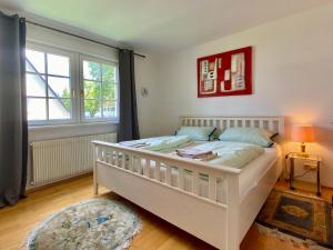 a bedroom with a white bed and a window at Ferienhaus Köchlin in Lindau