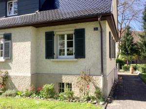 Ferienhaus Köchlin في لينداو: منزل به نافذة والمصاريع الخضراء