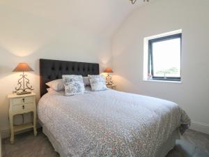 a bedroom with a bed with two lamps and a window at The Cottage in Chesterfield