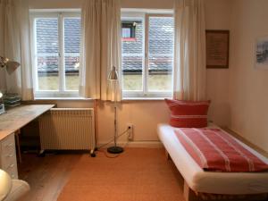 een slaapkamer met een bed, een bureau en ramen bij Ferienwohnung Altes Haus 4 in Lindau