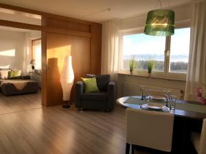 Una sala de estar con un sofá, una silla y una mesa. en Ferienwohnung Alina- Penthouse Wohnung mit atemberaubendem Blick zum Bodensee, en Kressbronn am Bodensee