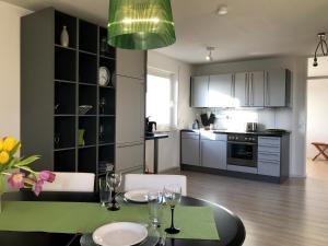 Una cocina y un comedor con mesa y sillas. en Ferienwohnung Alina- Penthouse Wohnung mit atemberaubendem Blick zum Bodensee, en Kressbronn am Bodensee 15 fotos más